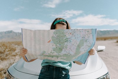 person reading map on desert road